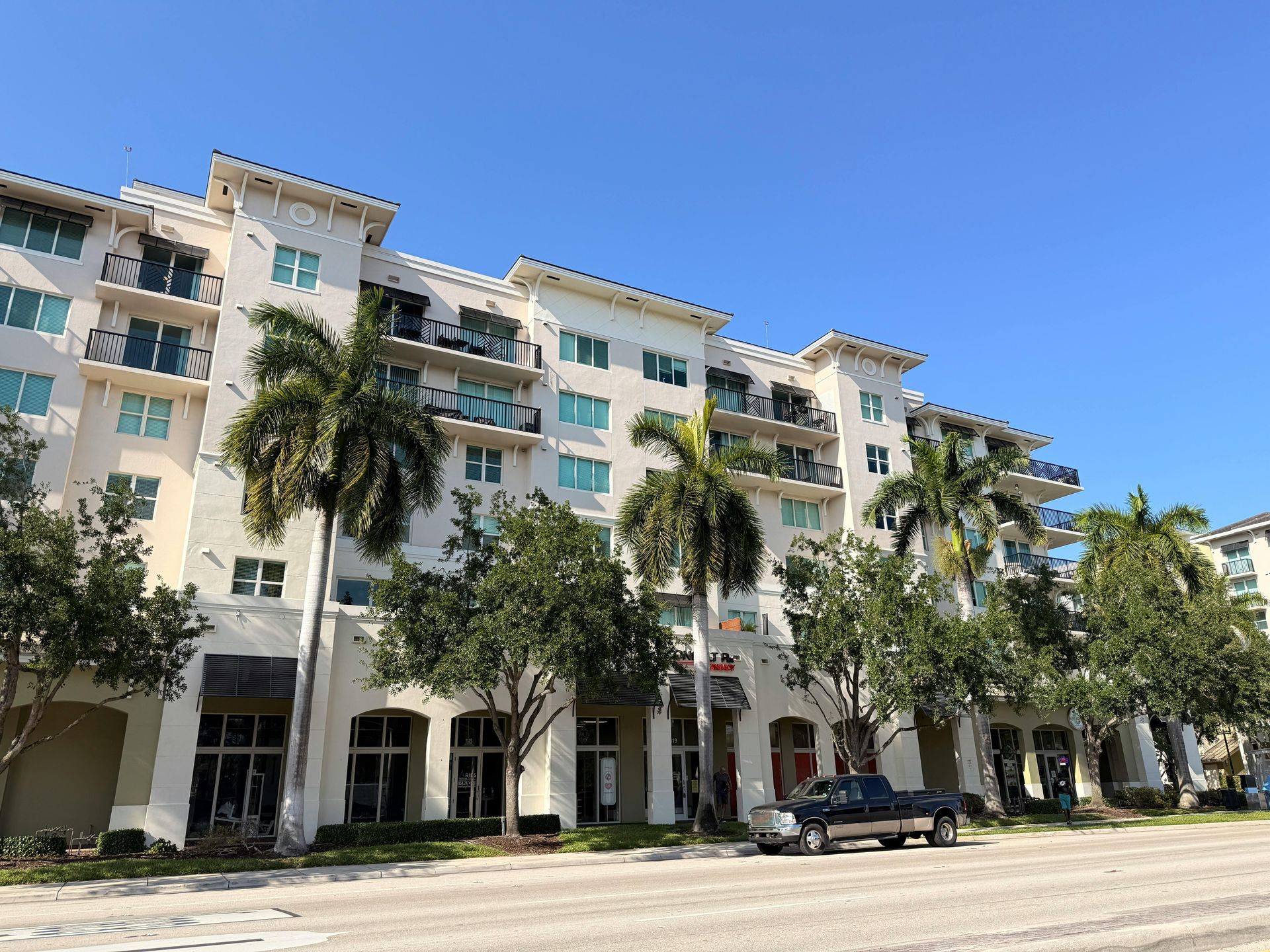 A large apartment building with palm trees in front of it
