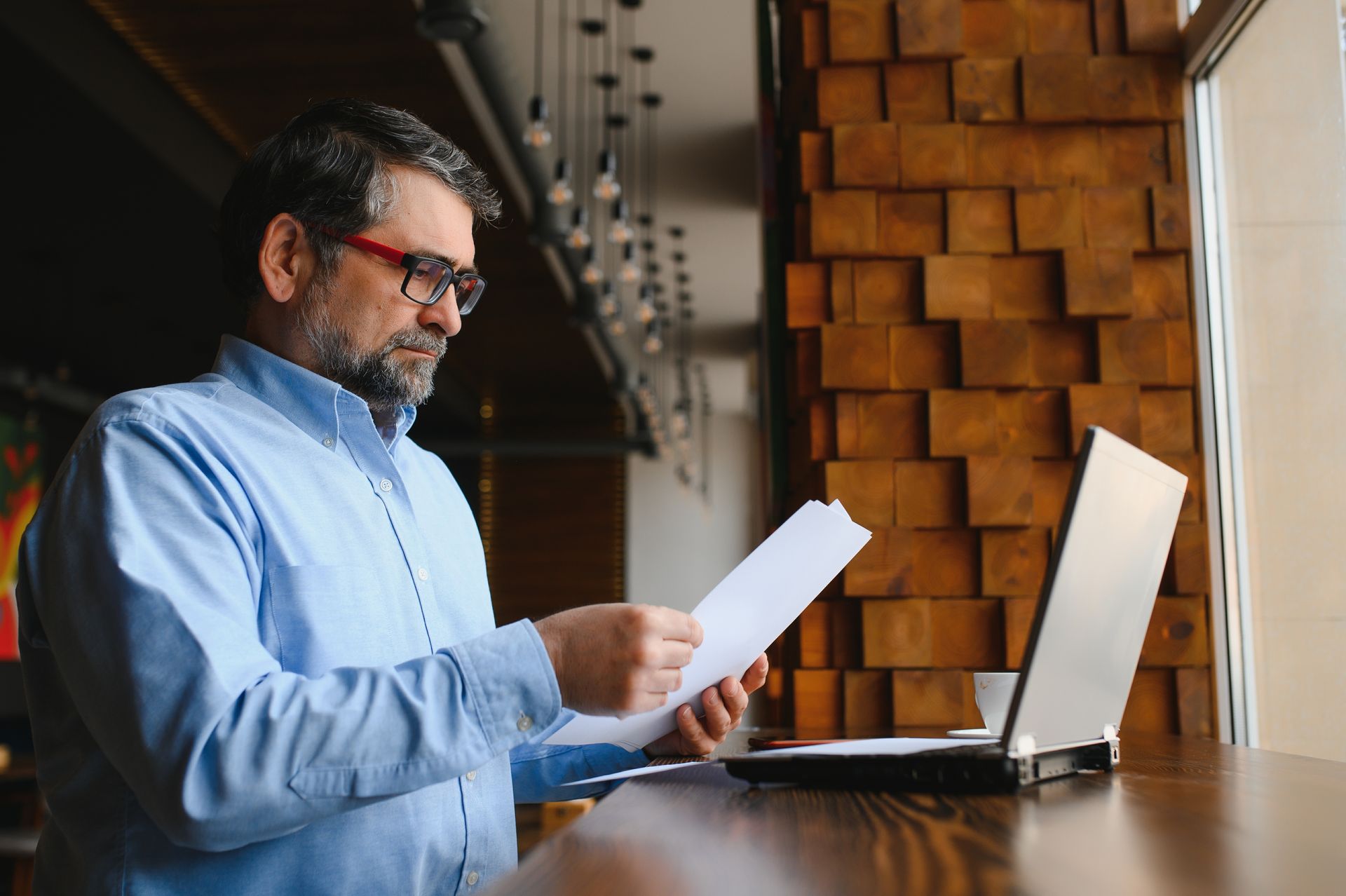A person is typing on a laptop next to a piece of paper that says insurance.