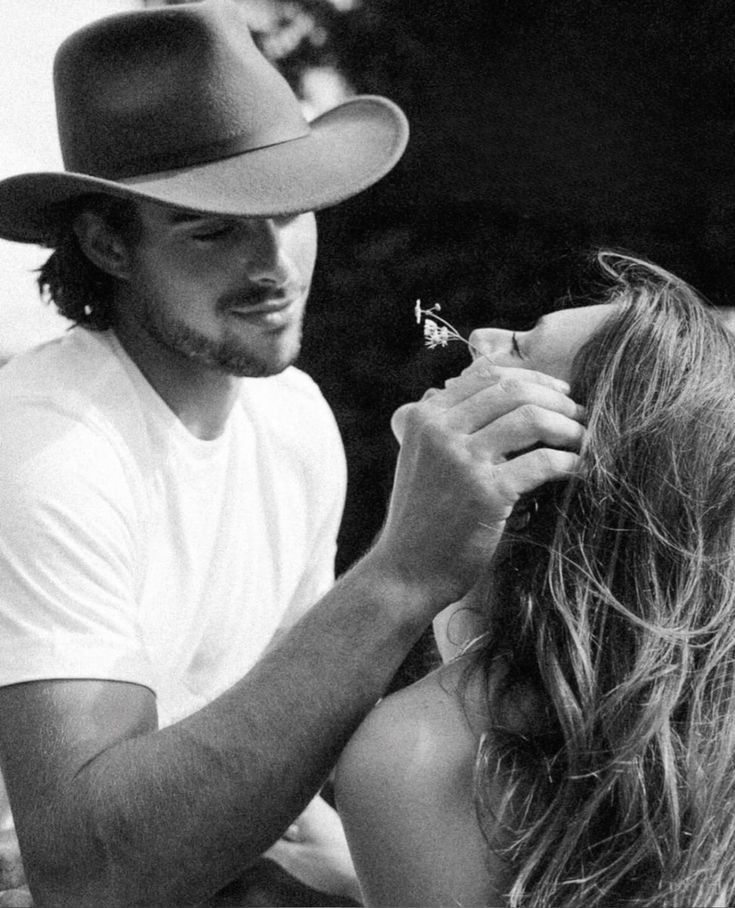 A woman is spraying perfume on her neck in a black and white photo.