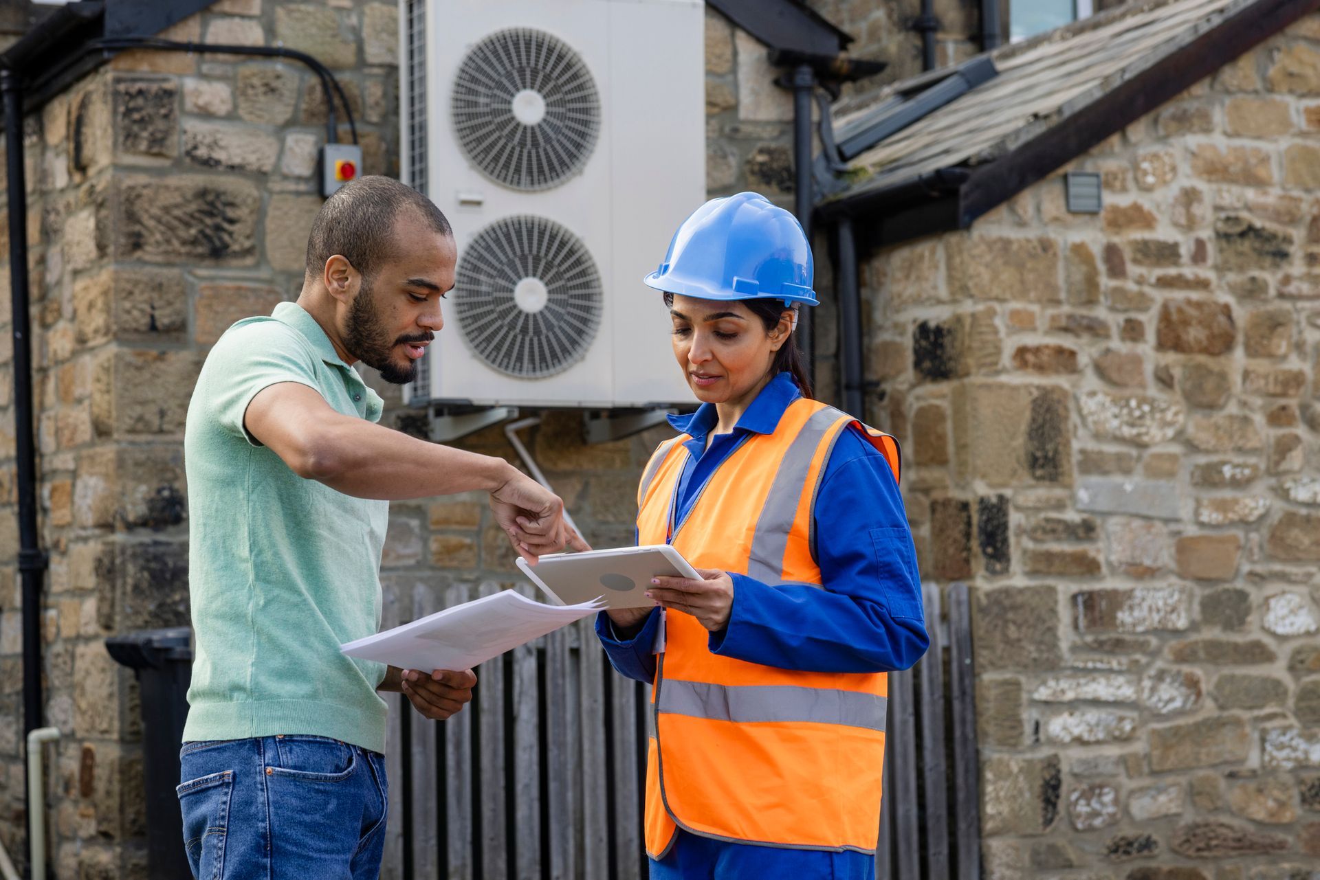 Engineer Working on an air source heat pump outside.