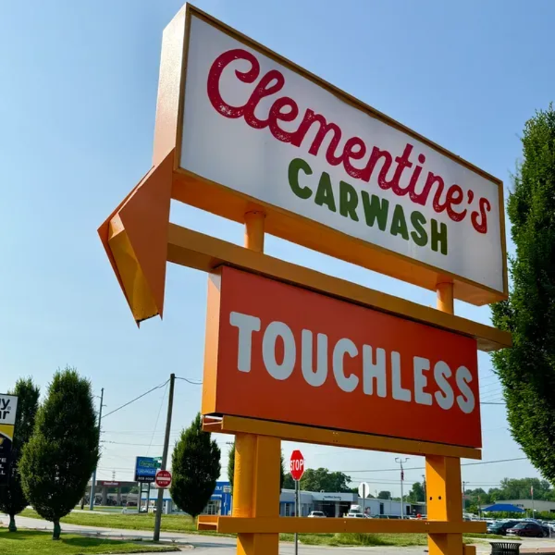 A man is standing in front of a clementine 's car wash