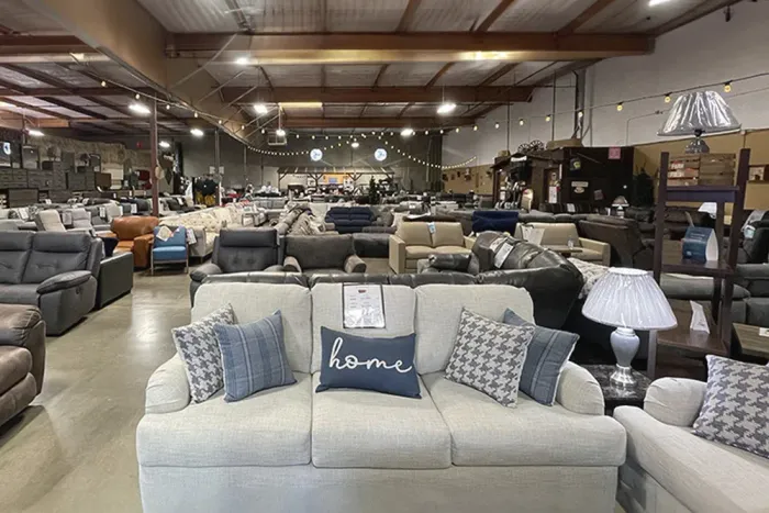 Interior of a furniture store filled with sofas, chairs, and lamps.