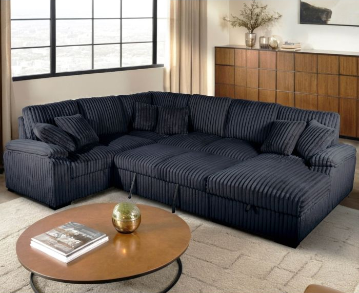 Dark blue corduroy sectional sofa in a living room, round coffee table in front.