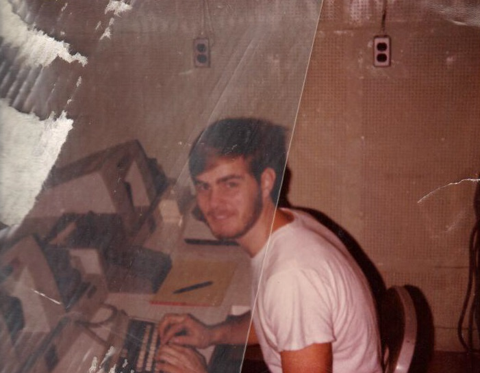 A man in a white shirt is sitting at a desk