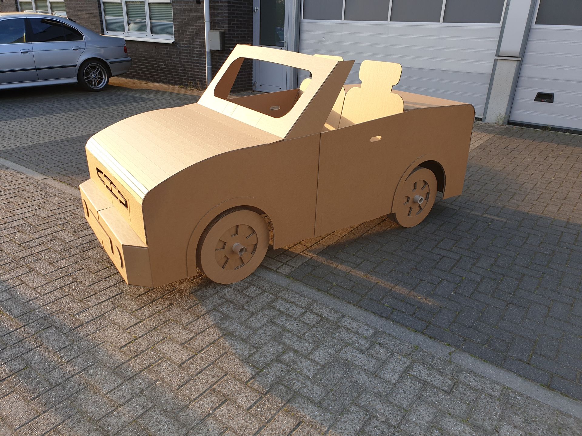 Langs de kant van de weg staat een kartonnen auto geparkeerd