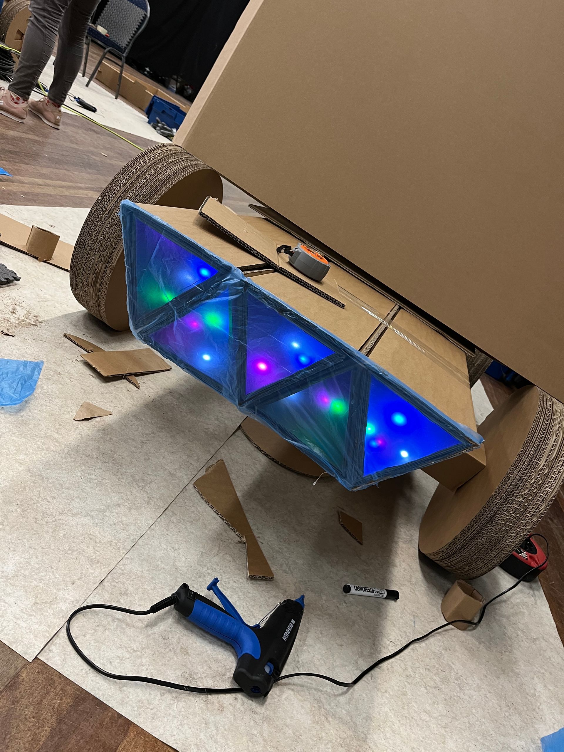 Op de grond staat een kartonnen doos met lampjes erop.