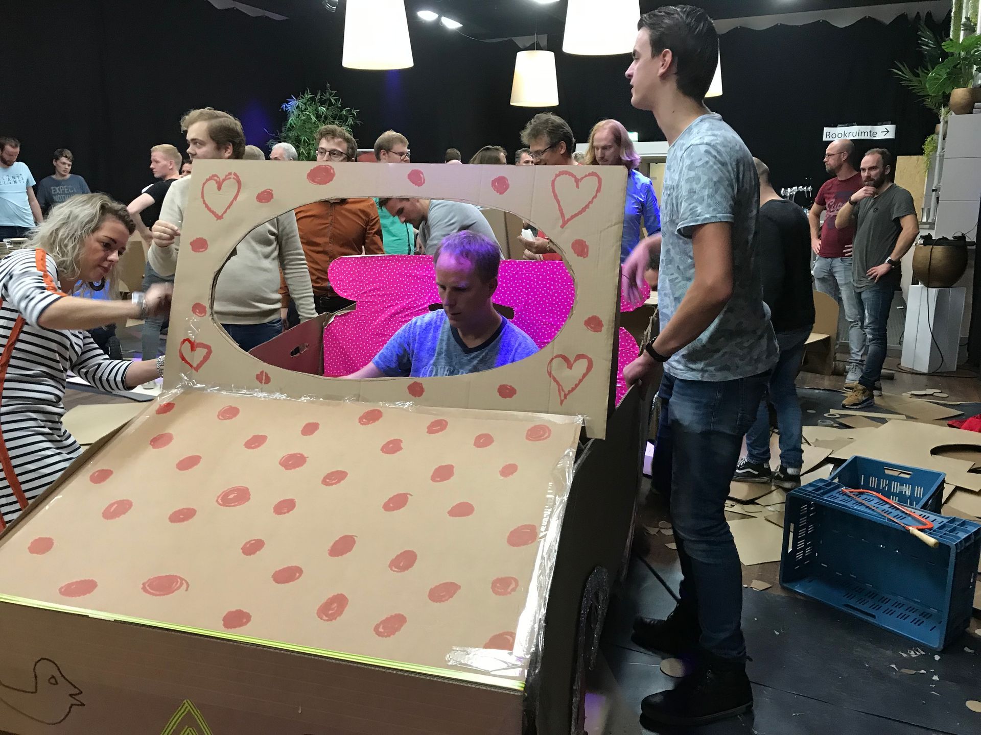 Een groep mensen staat rond een kartonnen doos met hartjes erop.