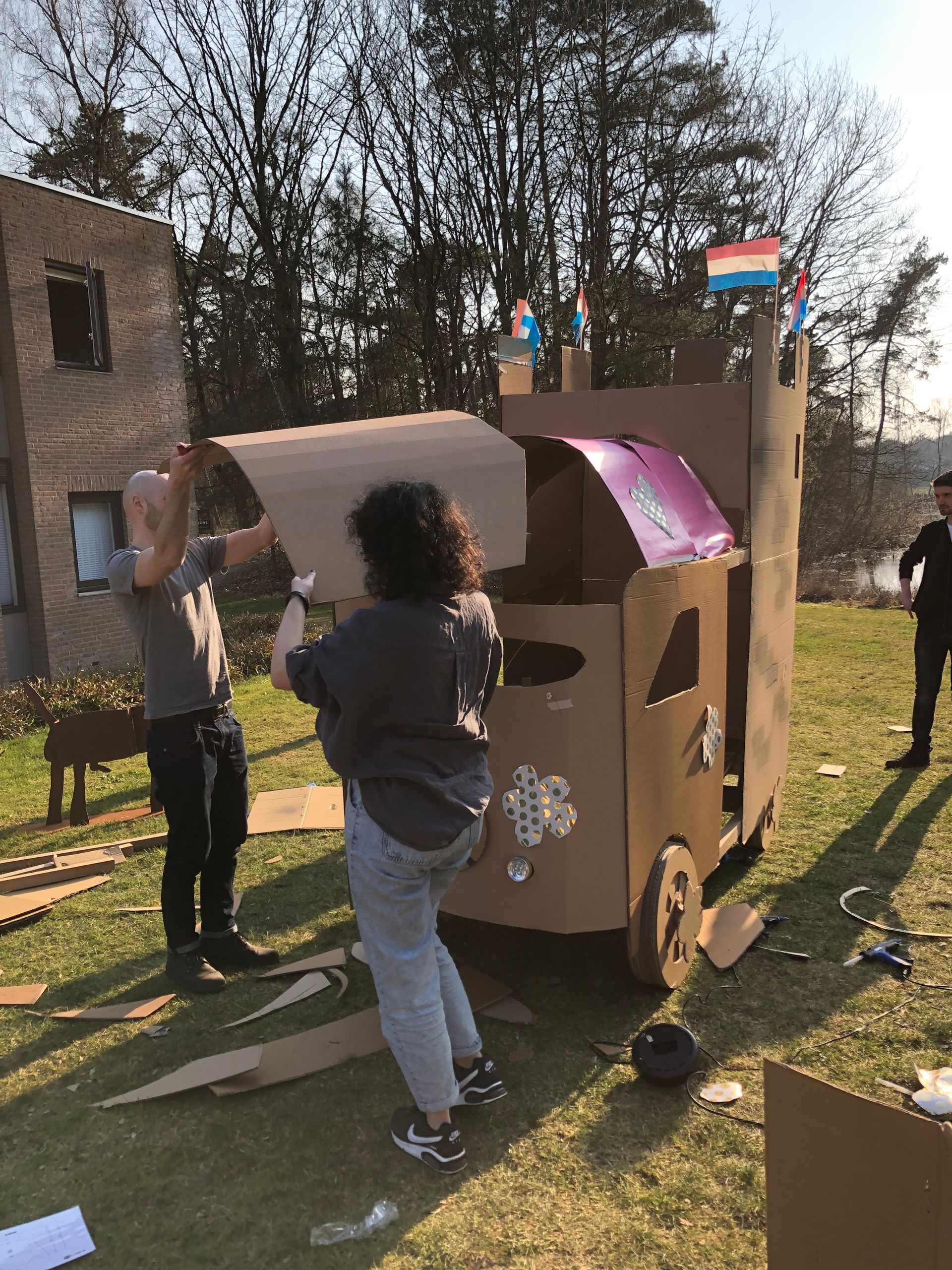 Een groep mensen werkt aan een kartonnen kasteel.