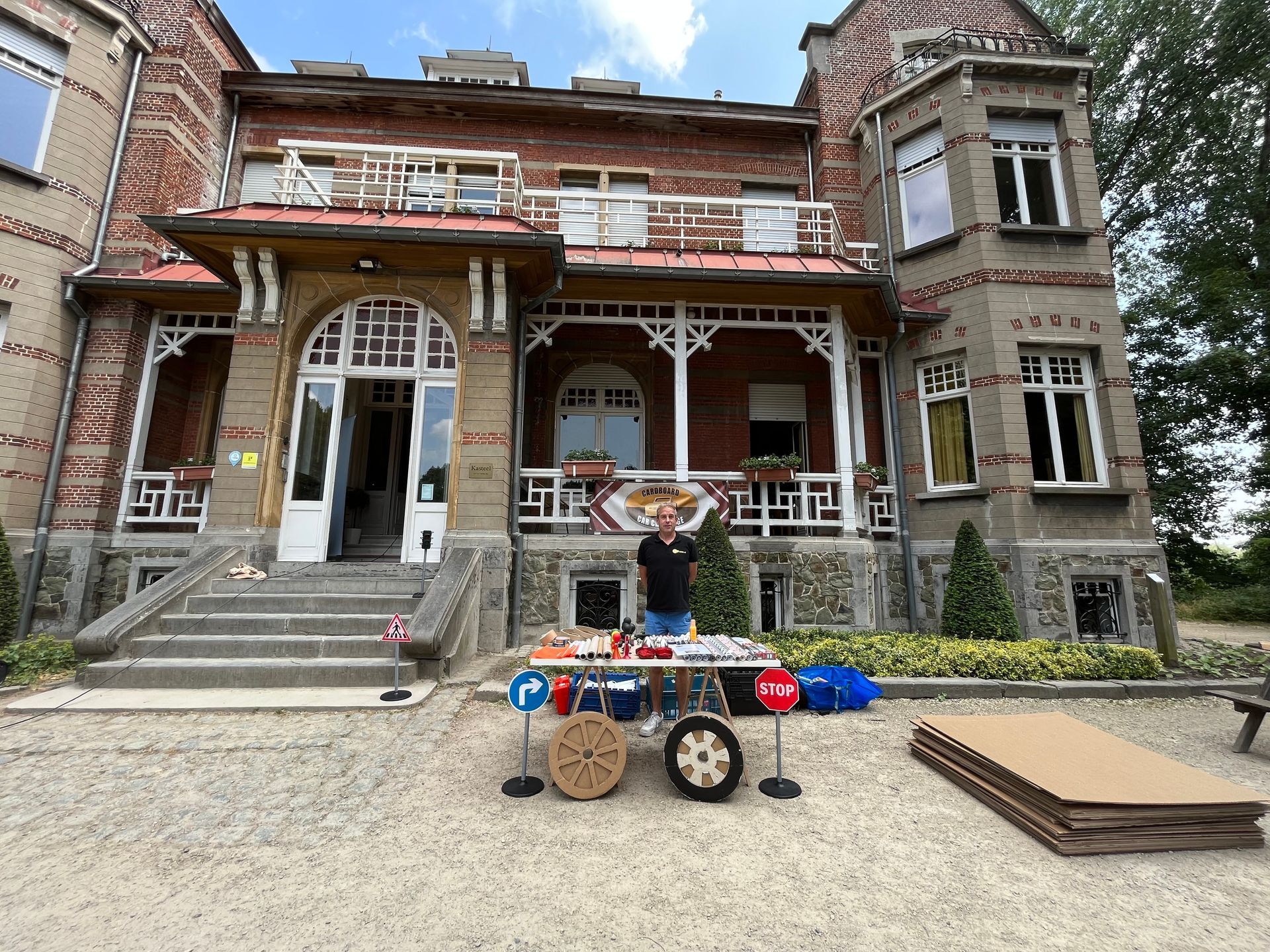 Voor een groot bakstenen gebouw staat een man.