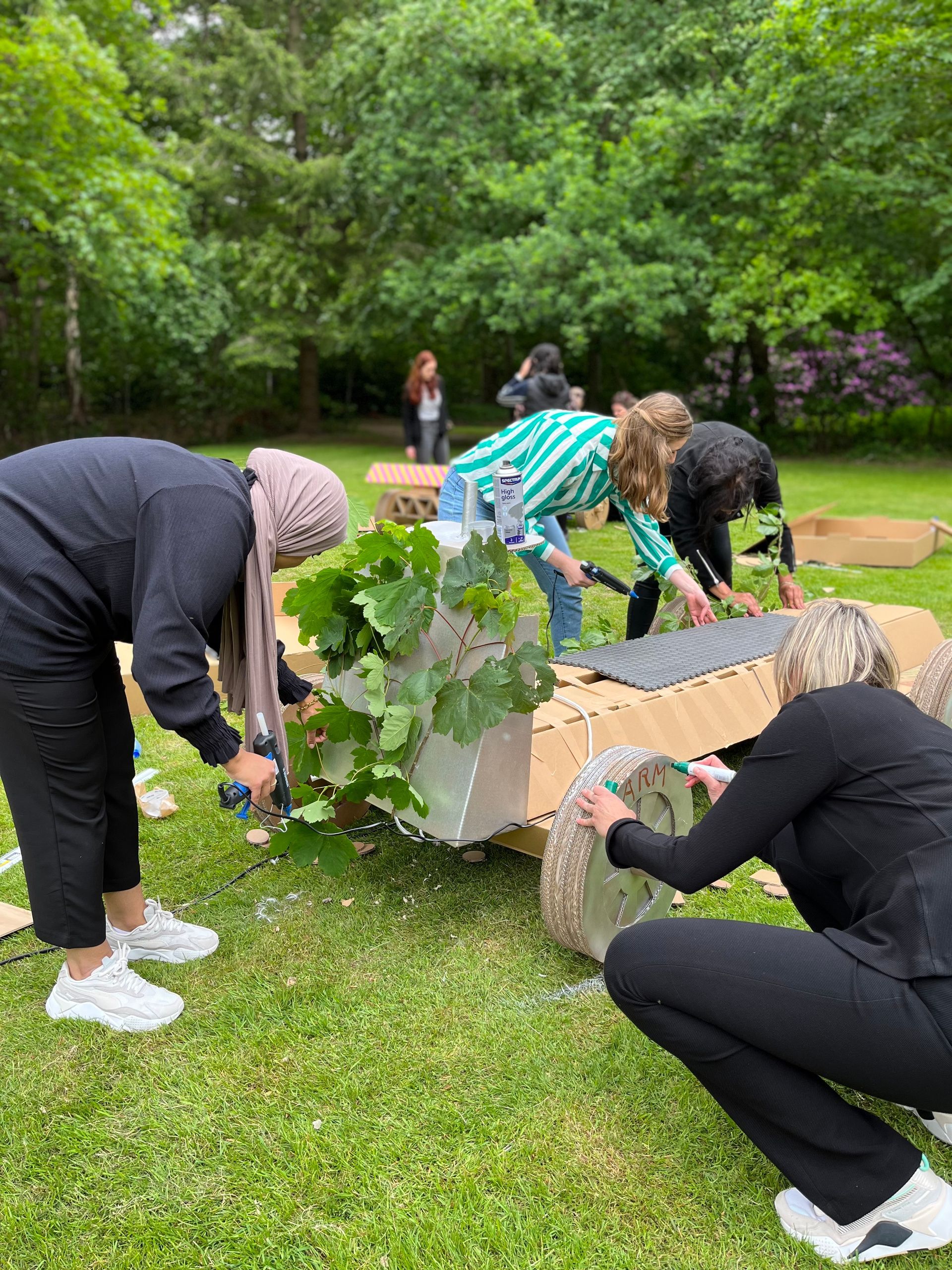 Een groep mensen werkt op een bankje in een park.