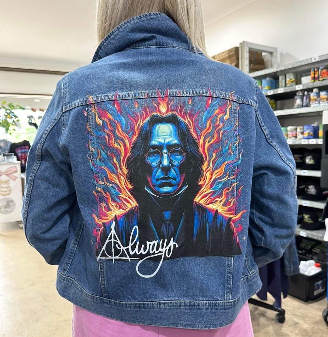 Person wearing denim jacket with Snape artwork on back, flames, “Always” signature, store setting.— That Printed Vinyl Place in Heatley, QLD