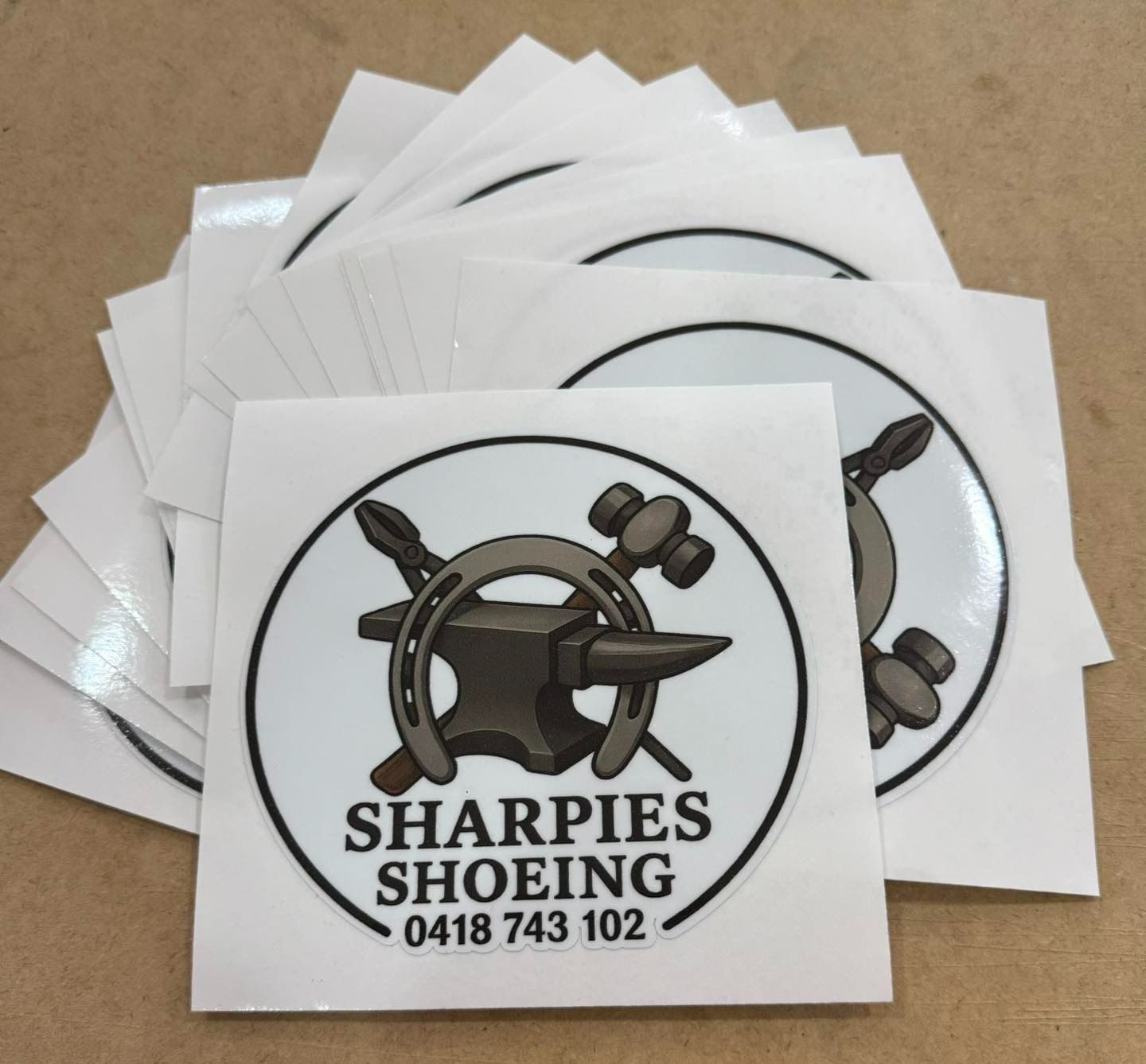 Stack of White, Square Stickers with A Horseshoe, Anvil, and Hammer Logo — That Printed Vinyl Place in Heatley, QLD