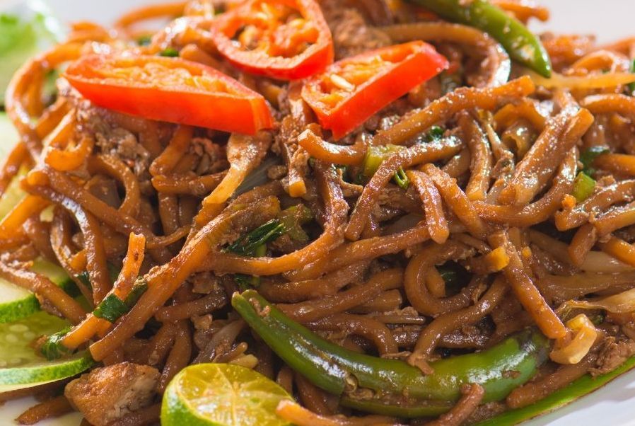 A white plate topped with rice and meat on a table