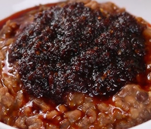 A close up of a bowl of food with sauce on top