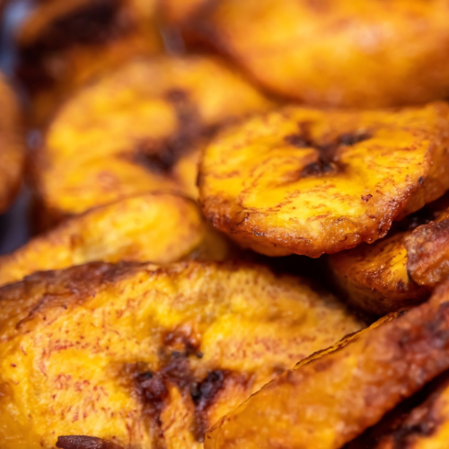 A close up of a pile of fried plantains on a table.
