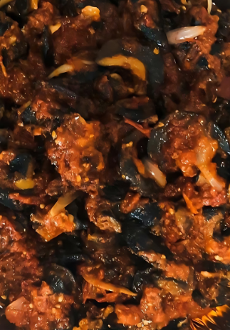 A close up of a foil container filled with meat and vegetables