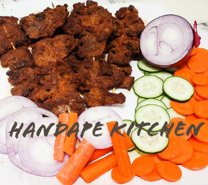 A plate of food with carrots onions and cucumbers says handape kitchen