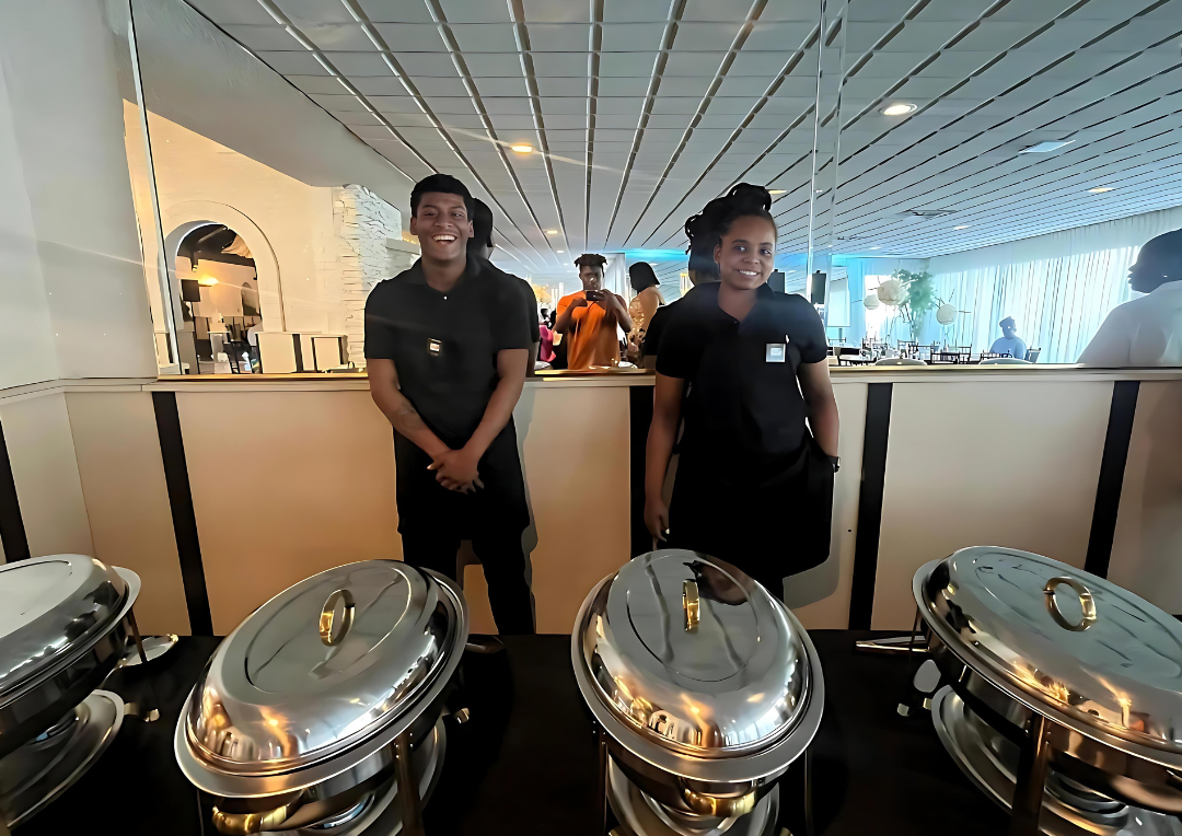A man and a woman are standing in front of a buffet line.