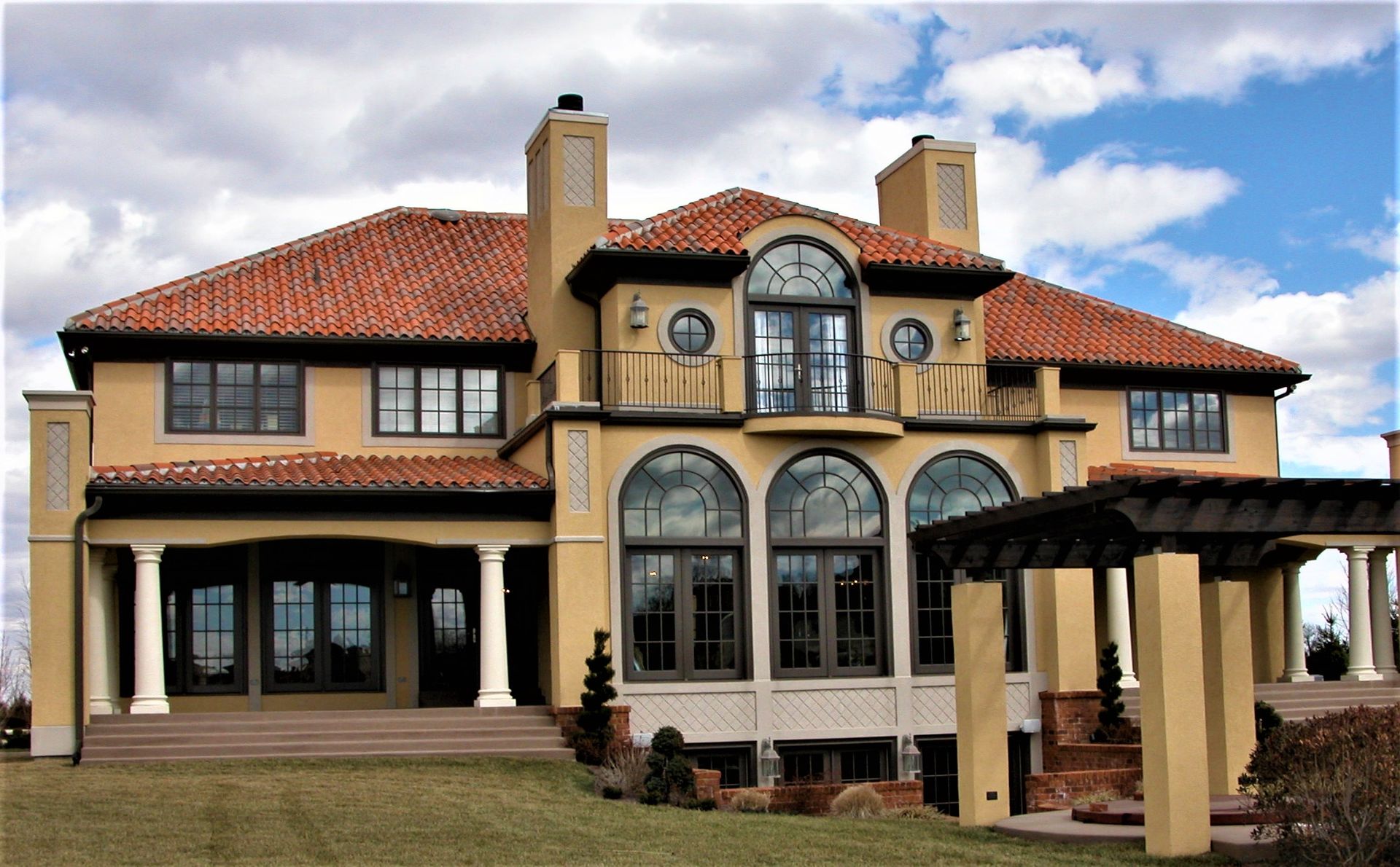 A Large House With Arched Windows And A Red Tile Roof - Carmel, IN - Goldberg Design Group