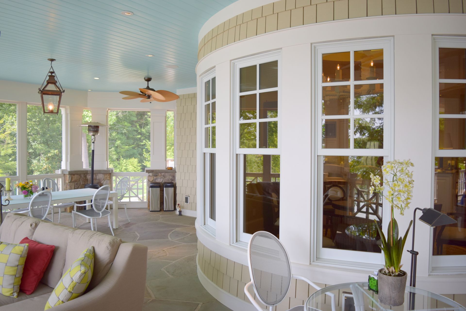a large room with a lot of windows and a ceiling fan