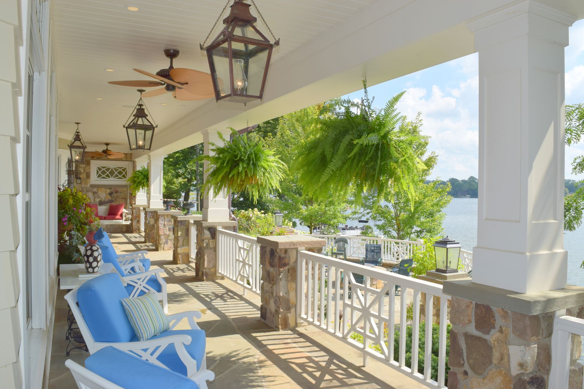 a porch with chairs and a ceiling fan overlooking a body of water .
