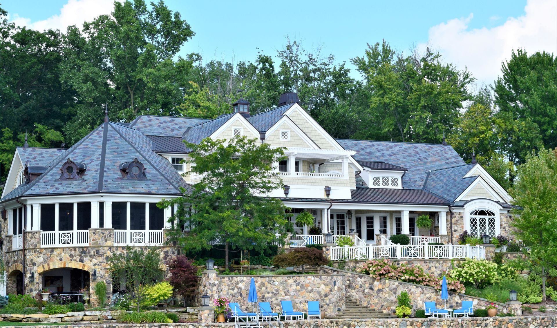 a large white house with a blue roof is surrounded by trees .