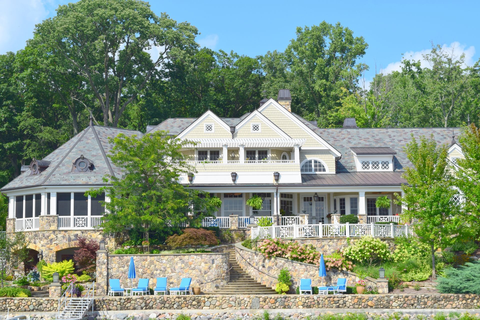 a large house sits on a hill overlooking a lake