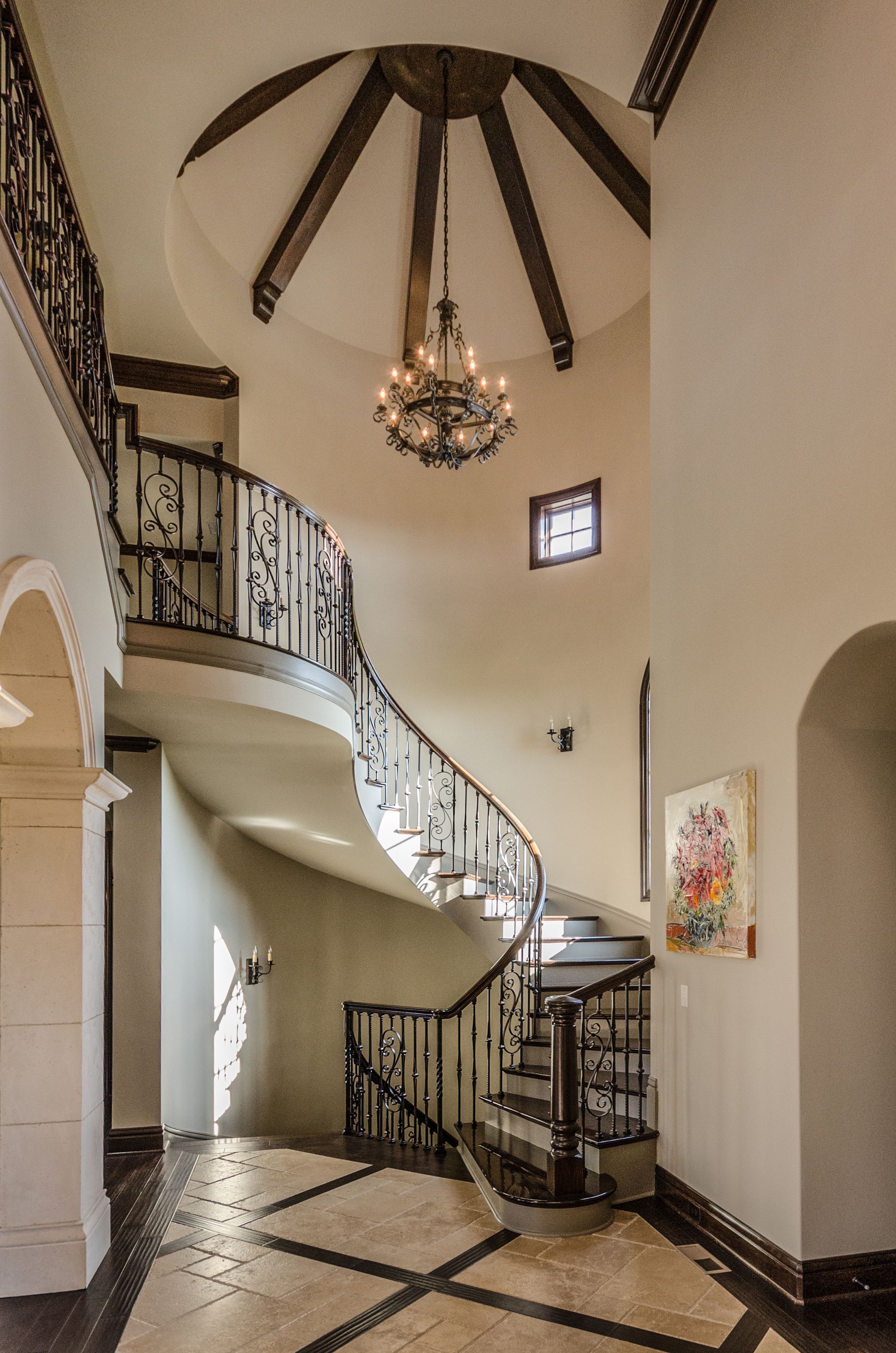 A Spiral Staircase In A House With A Chandelier - Carmel, IN - Goldberg Design Group