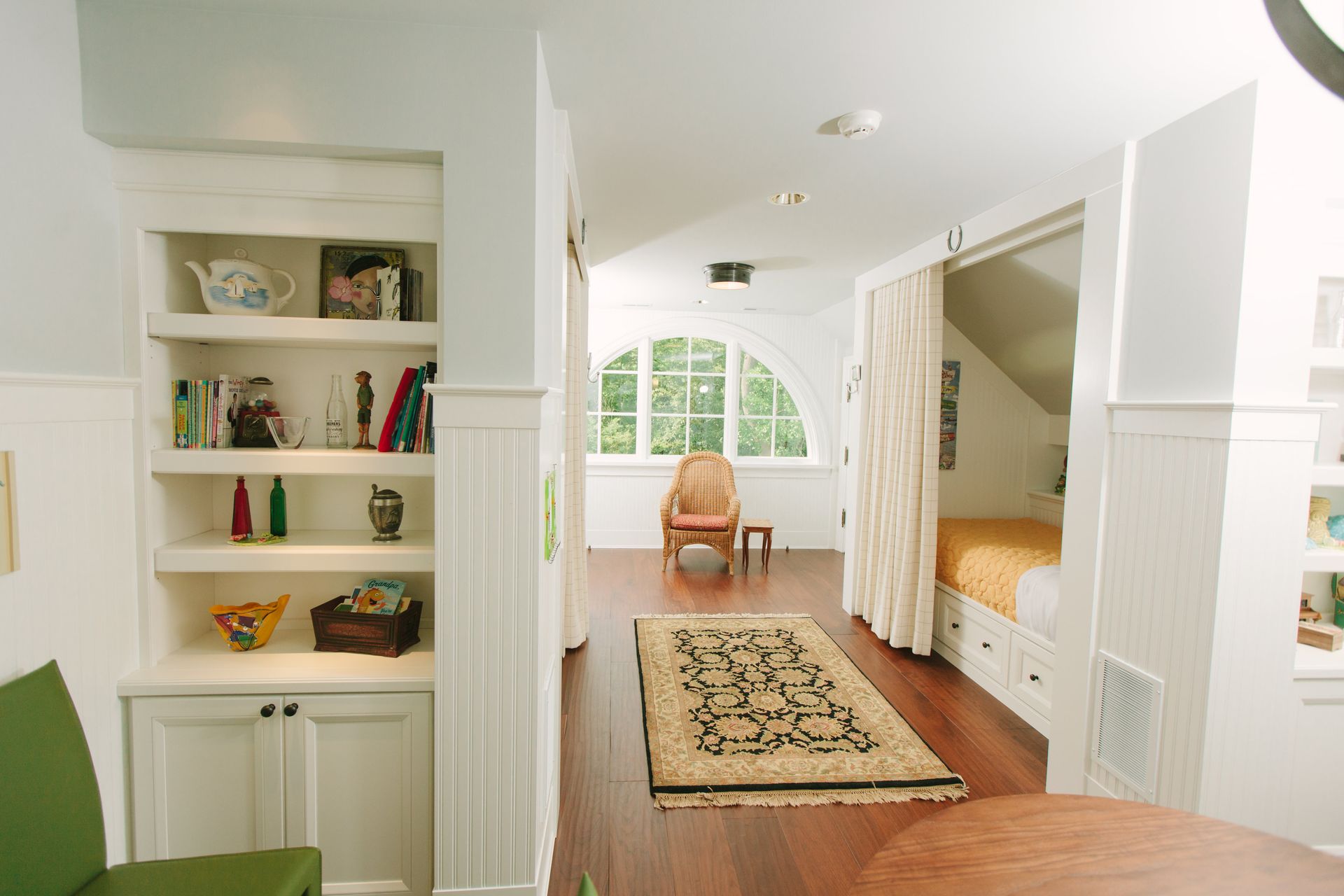 A Living Room With A Green Chair And A Rug - Carmel, IN - Goldberg Design Group