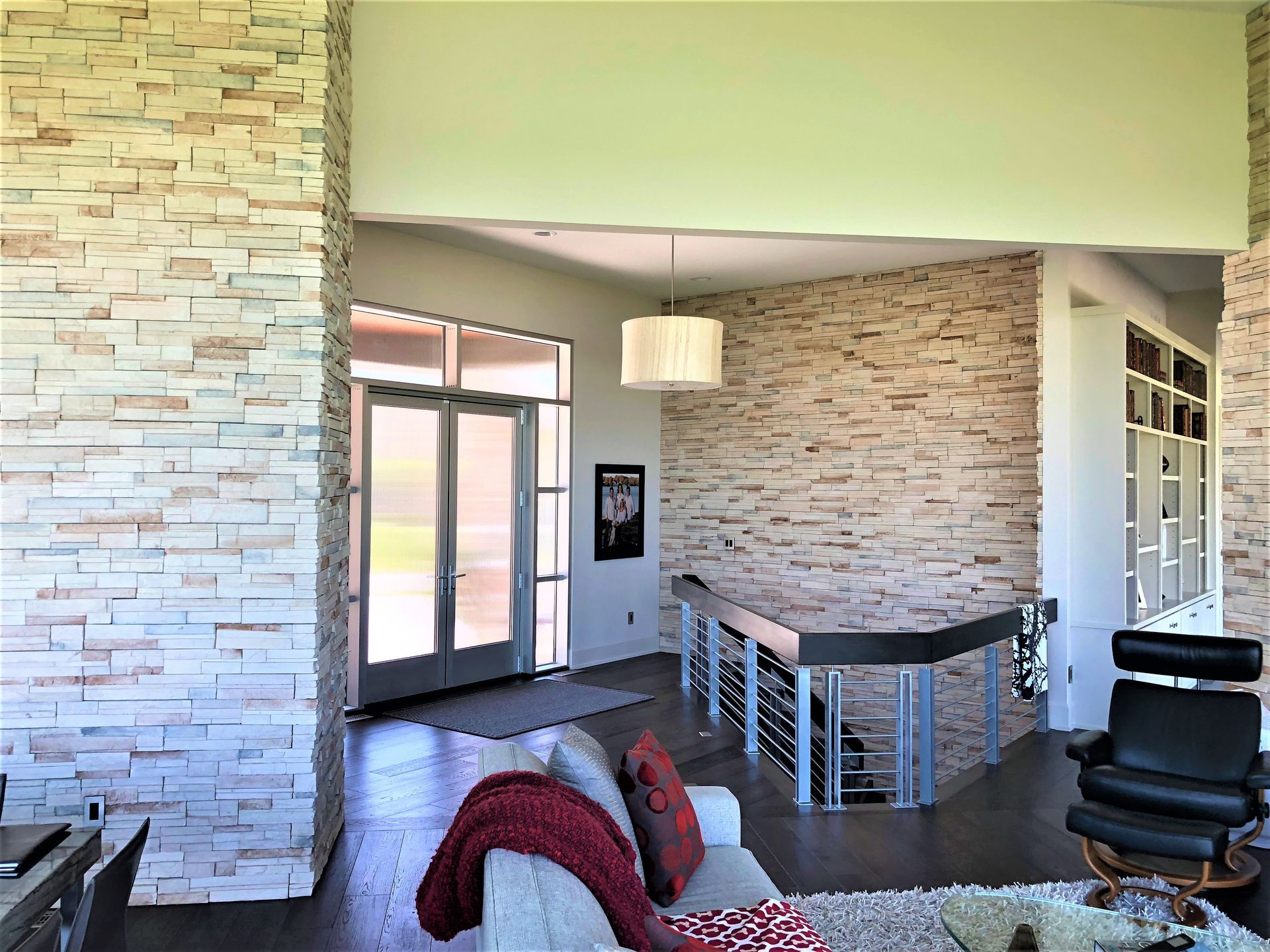 A Living Room With A Couch And Chair And A Brick Wall - Carmel, IN - Goldberg Design Group
