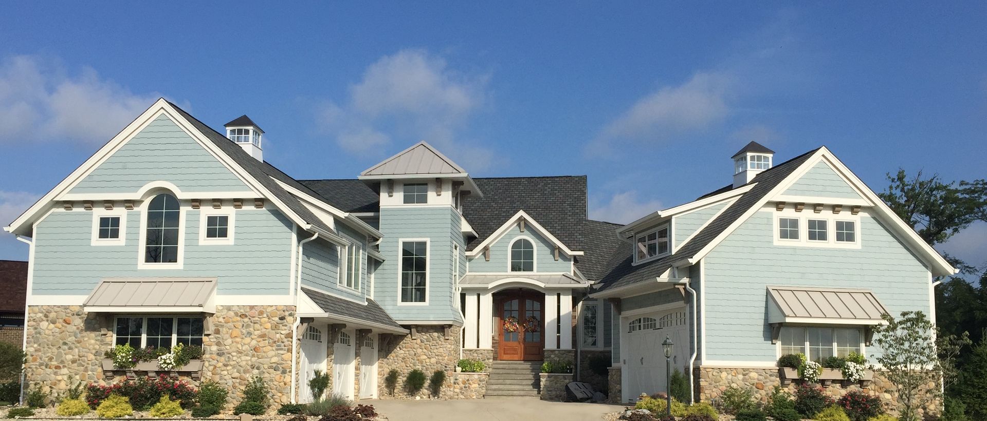 a large house with blue siding and a gray roof