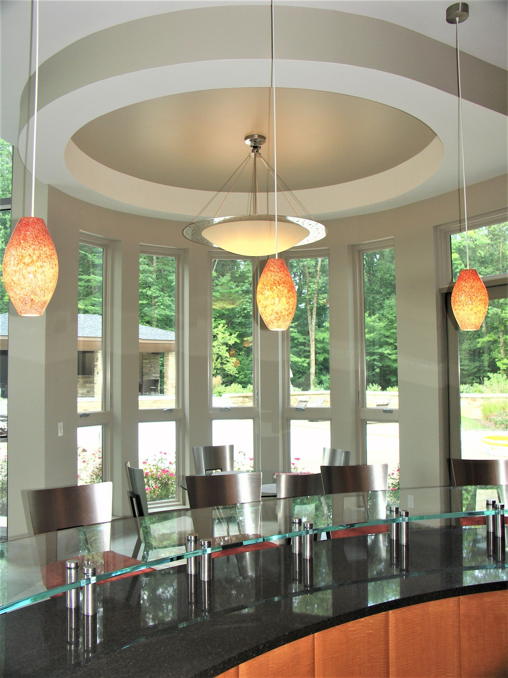 A Dining Room With A Circular Ceiling And A Glass Table - Carmel, IN - Goldberg Design Group