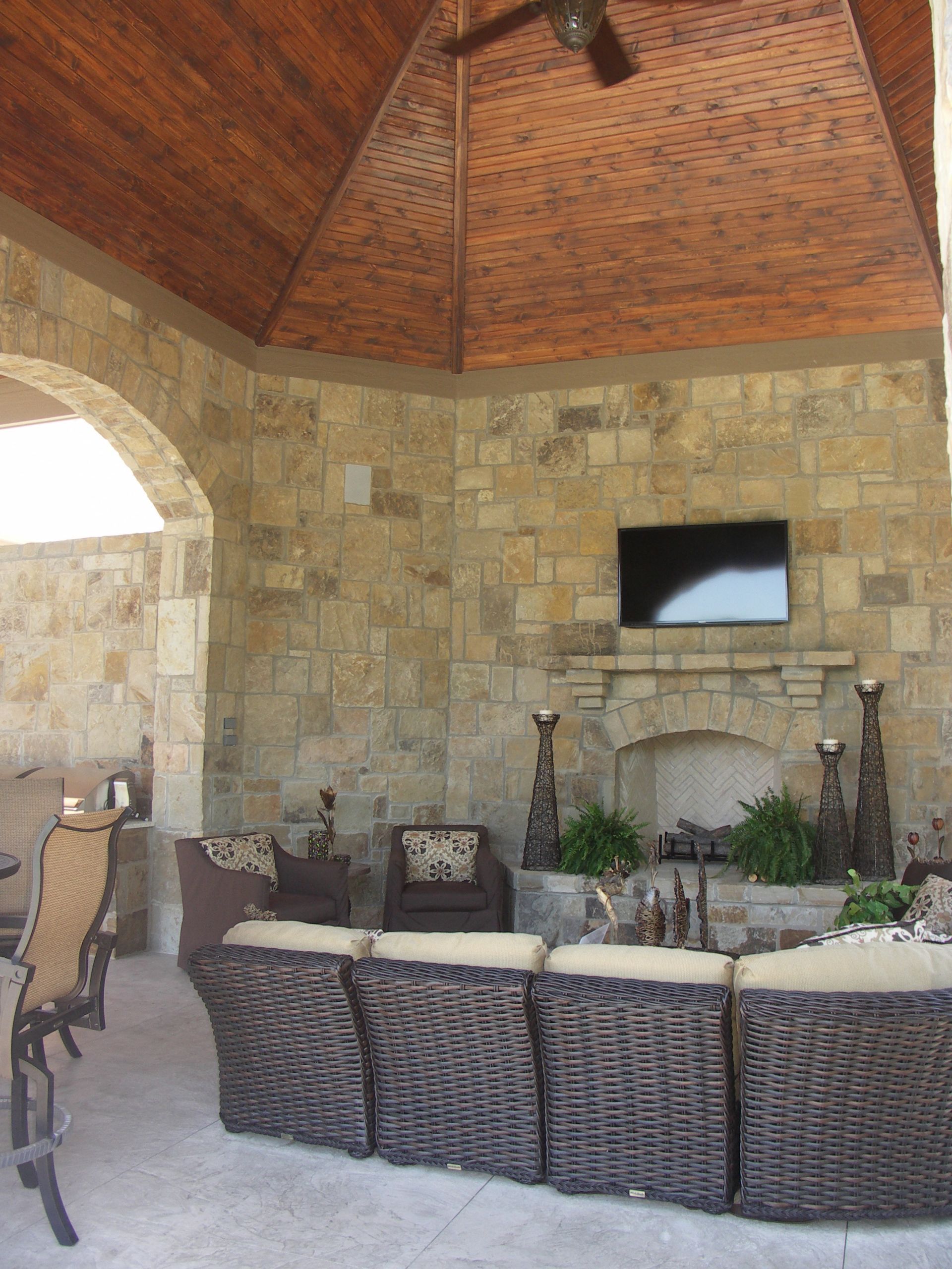 A Living Room With Wicker Furniture And A Fireplace - Carmel, IN - Goldberg Design Group