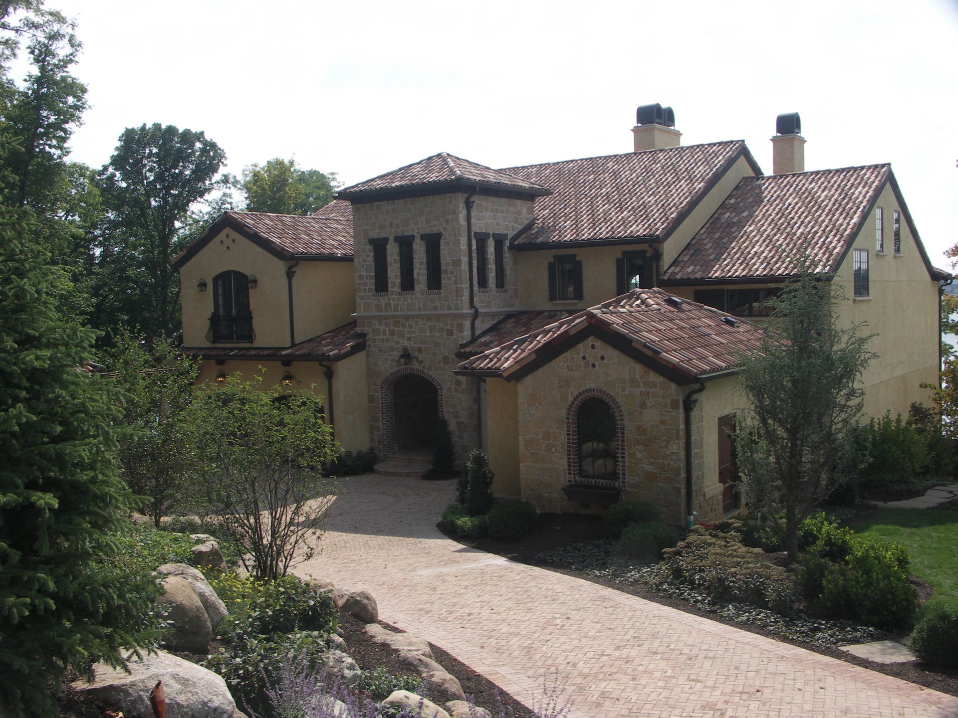 A Large Mediterranean House With A Driveway Leading To It - Carmel, IN - Goldberg Design Group