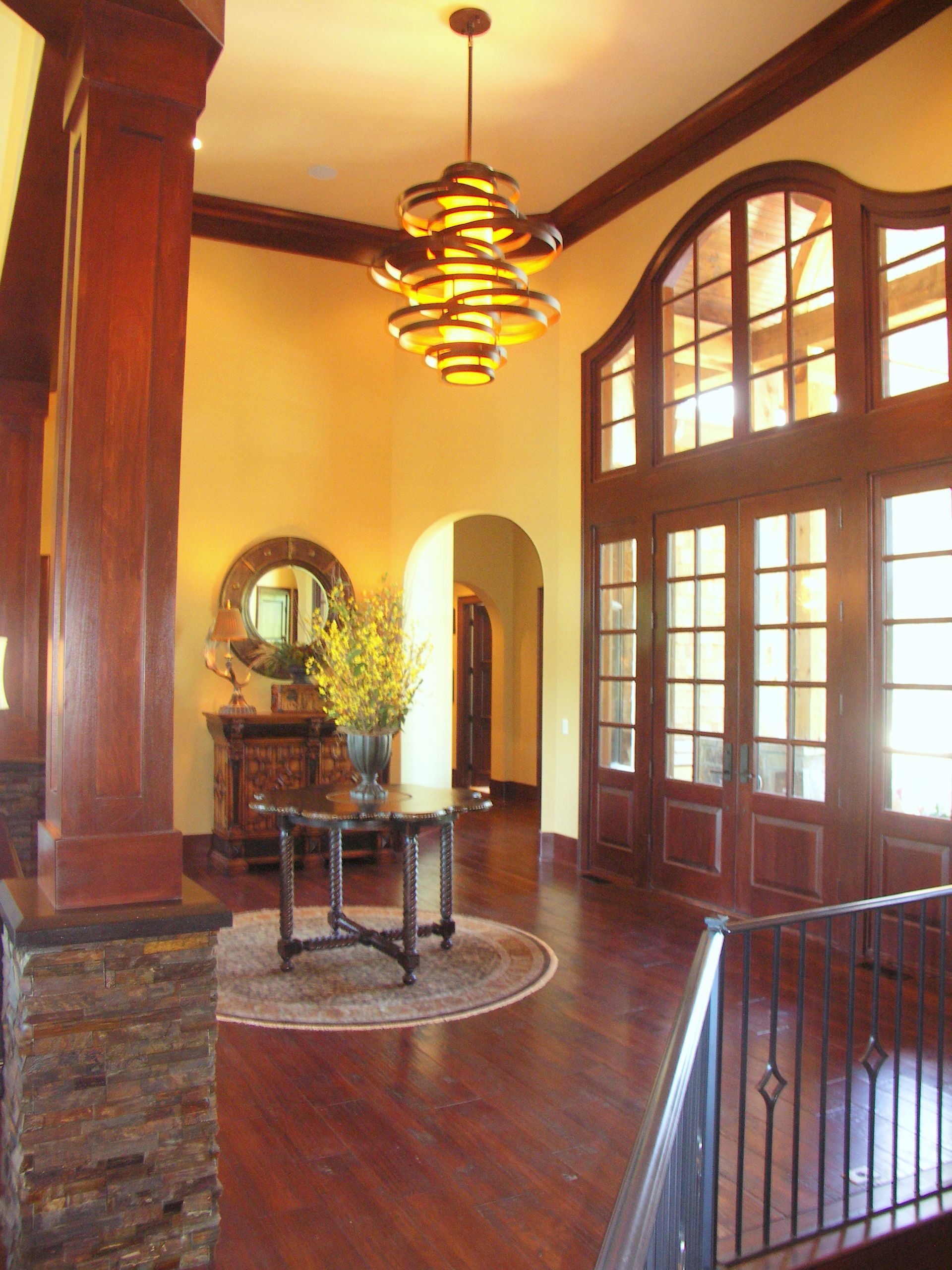 A Large Room With Lots Of Windows And A Chandelier Hanging From The Ceiling - Carmel, IN - Goldberg Design Group