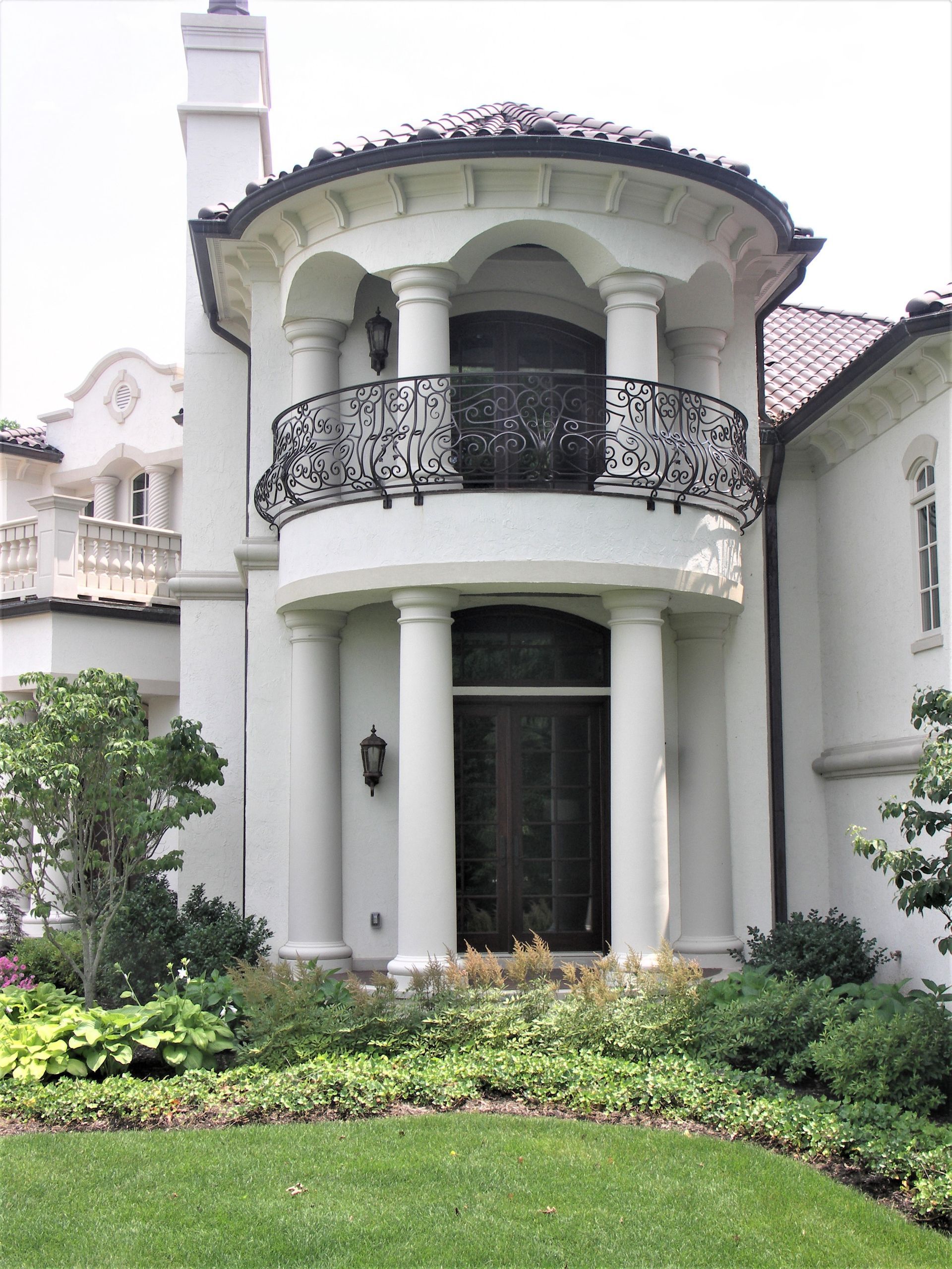 A Large Mediterranean White House With A Balcony And Columns - Carmel, IN - Goldberg Design Group