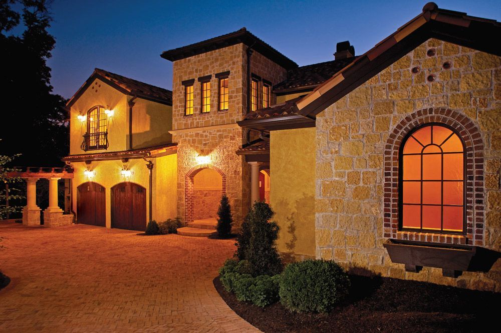 a large house with a lot of windows is lit up at night