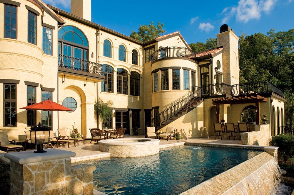 A Mediterranean Style House With A Large Swimming Pool In Front Of It - Carmel, IN - Goldberg Design Group