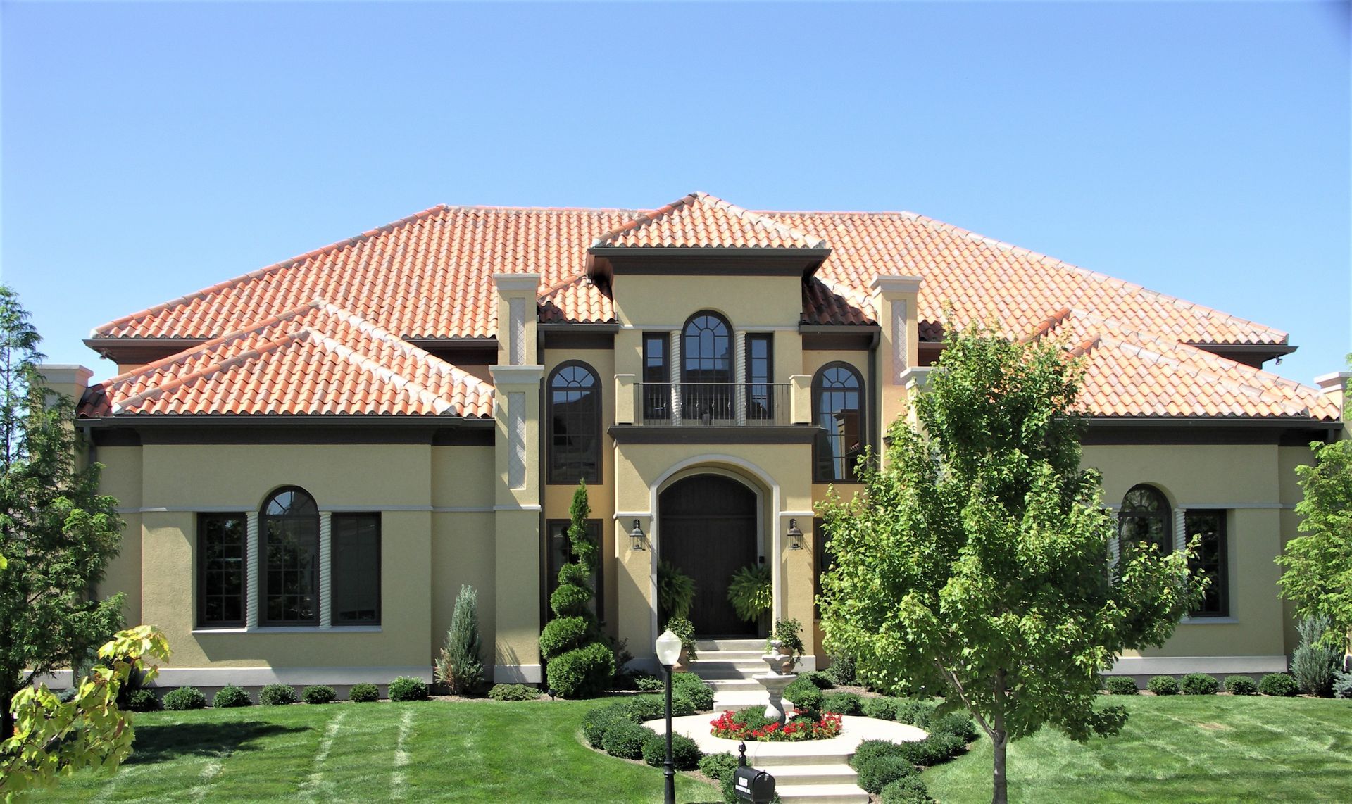 A Large House With A Tiled Roof Is Surrounded By Trees - Carmel, IN - Goldberg Design Group
