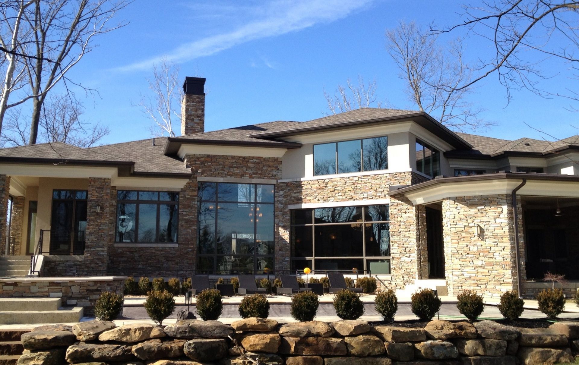 A Large House With A Brick Wall In Front Of It - Carmel, IN - Goldberg Design Group