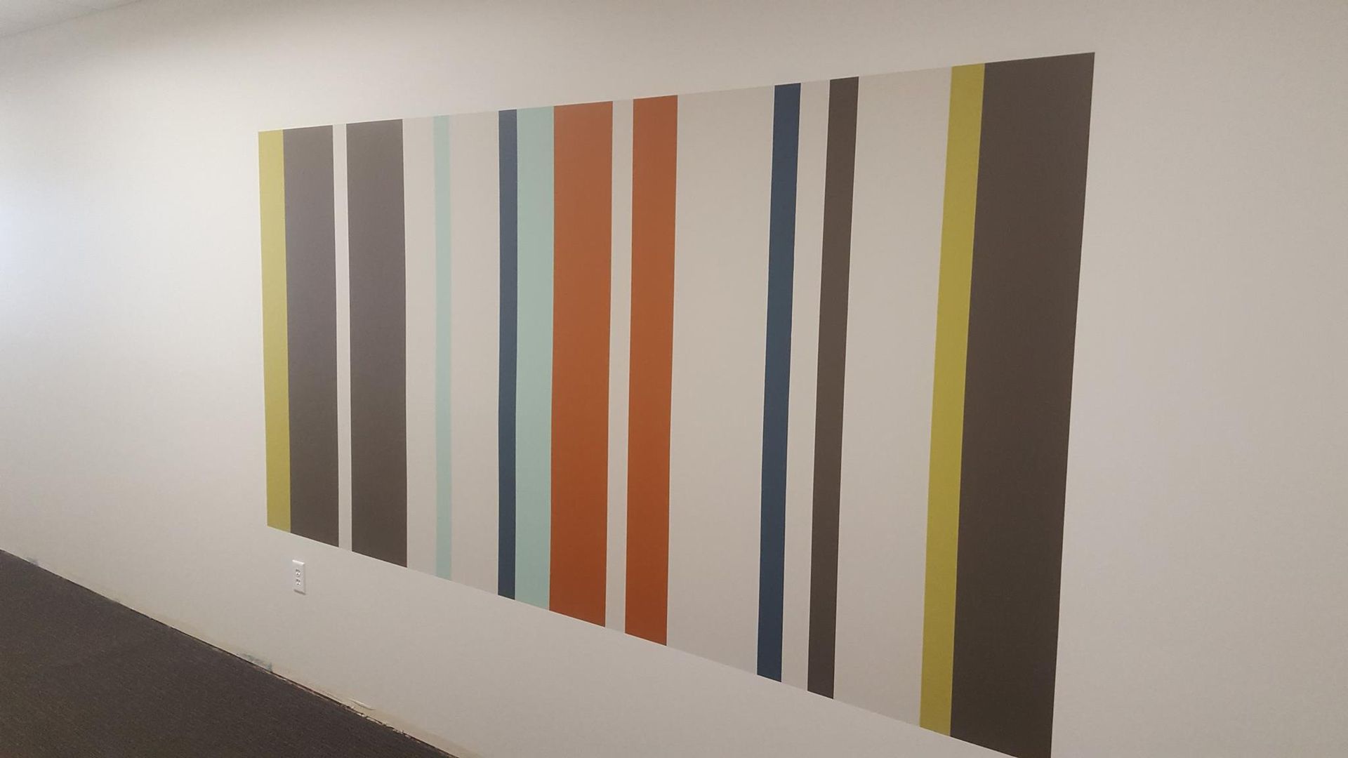 A wall with colorful stripes painted on it