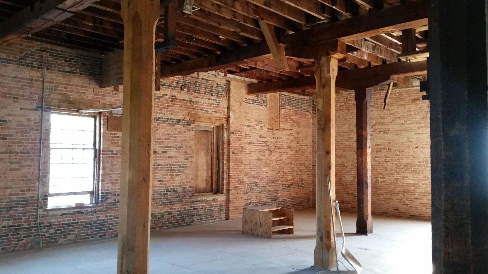 An empty ice rink with a blue fence and bleachers.