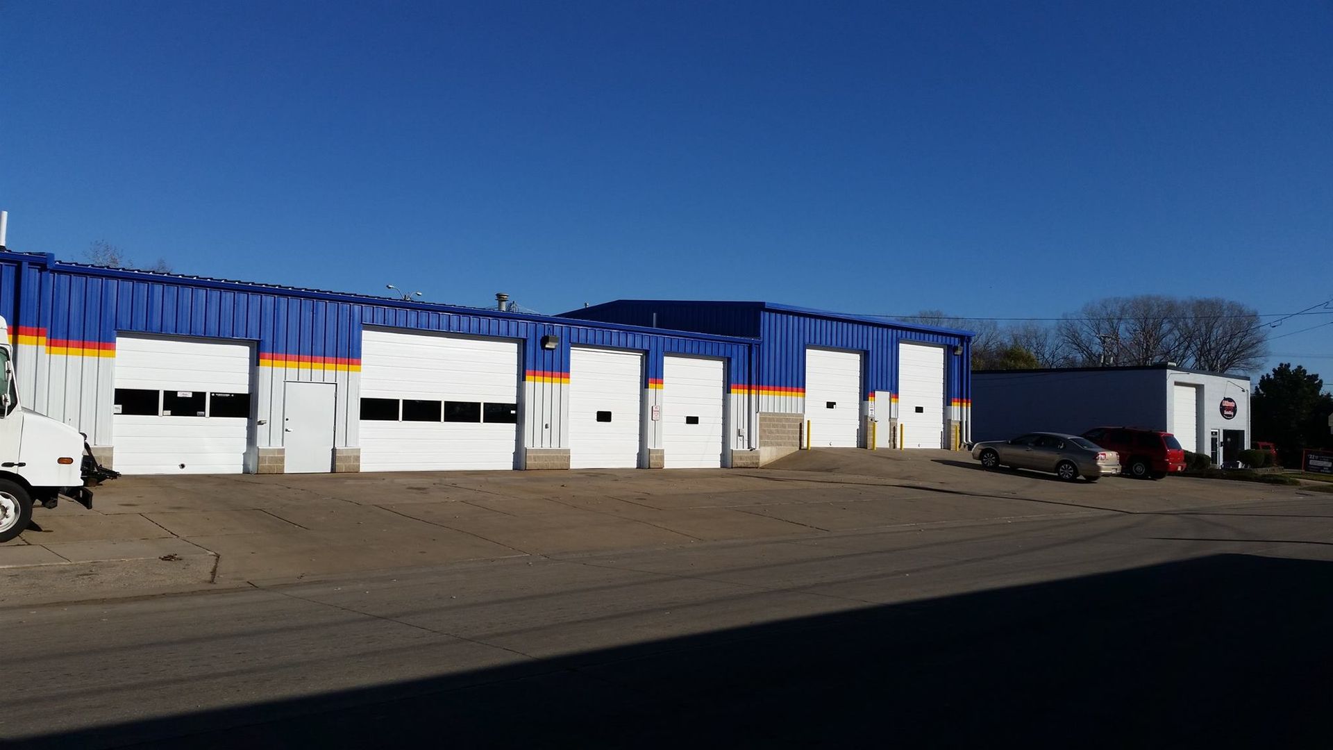 A truck is parked in front of a building with a lot of garage doors.
