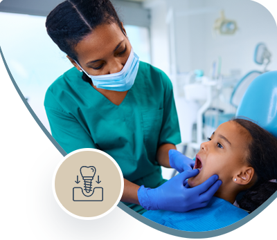 Dentist in teal scrubs examining a child’s teeth in a bright dental clinic