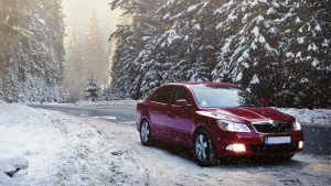 Red car driving in winter | Eagle Transmission & Auto Repair - Austin-North