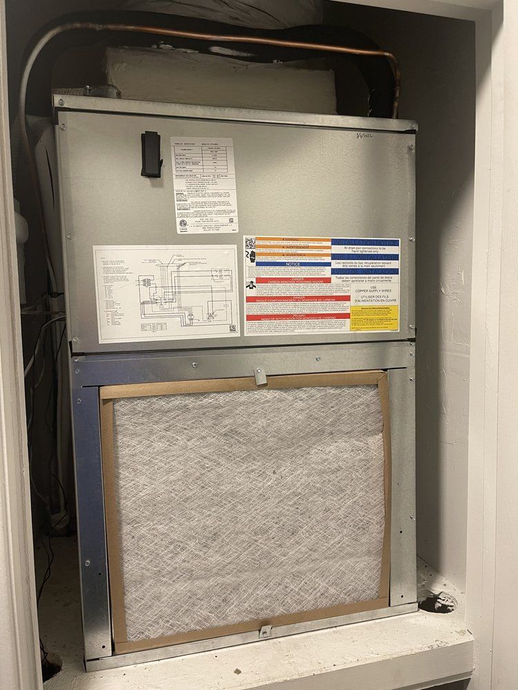A furnace unit with a visible air filter in a utility closet.