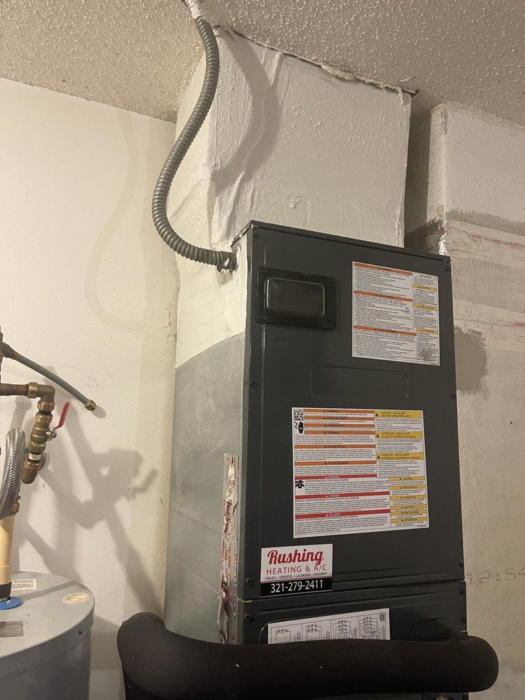 Furnace unit against a white wall with ductwork. Electrical conduit runs to the ceiling.