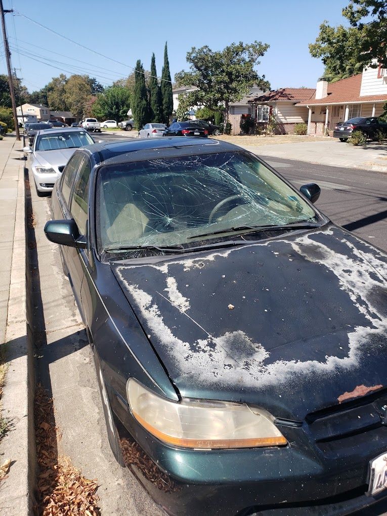 A black car is parked on the side of the road