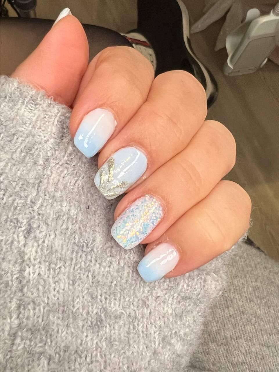 A close up of a person 's hand with blue and white nails