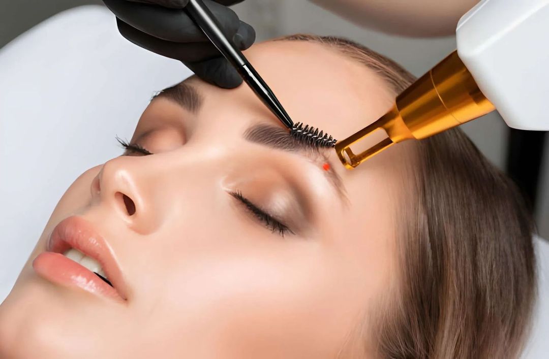 Hand with oval-shaped nails painted in a soft pink hue, extended against a matching pink background.